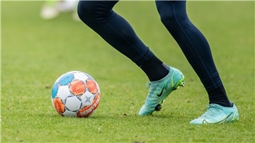 Füße eines Fußballers spielen beim Training von Hertha BSC einen Ball.