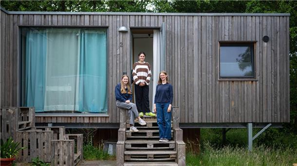 Neben der Schule in Mini-Häusern wohnen Die drei Schülerinnen Anna, Paulina und Hannah stehen vor einem Tiny House.