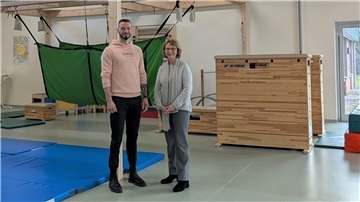 Ein Mann und eine Frau stehen in einer Turnhalle.