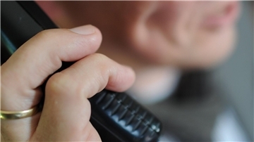 Frau mit Telefonhörer in der Hand