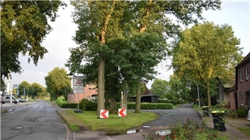 Die Eichen auf der Insel zwischen Landesstraße 122 (links) und Friedhofstraße (rechts) müssen nicht für einen Fahrbahnteiler weichen. Die Zufahrt hinter den Eichen wird dann gesperrt.