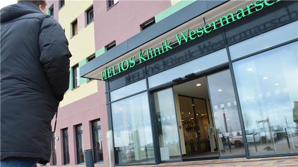 Ein Mann geht zum Eingang der Helios-Klinik Wesermarsch.