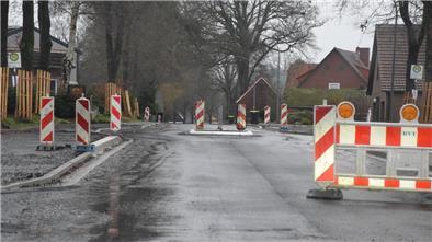 Die erste Asphaltschicht ist aufgetragen, der Fahrbahnteiler an der Ortsdurchfahrt in Rhadereistedt ist gebaut, der Bereich an den Bushaltestellen muss noch gepflastert werden.