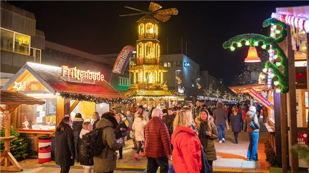 Die ersten Gäste des Bremerhavener Weihnachtsmarkt schlenden an den Buden vorbei.