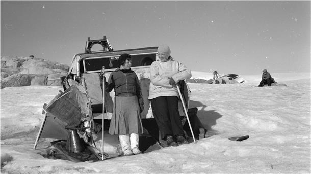 Die Ethnologin Aenne Schmücker zusammen mit ihrem Begleiter Joko auf Grönland vor einem von der Wegener-Expedition 1930/31 benutzten Motorschlitten.