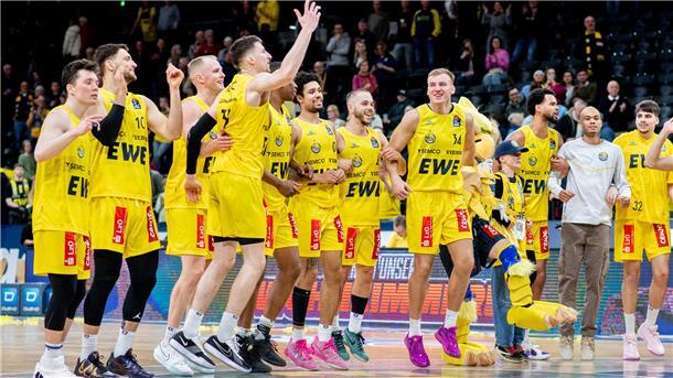 Eine Basketball-Mannschaft feiert hüpfend einen Sieg.