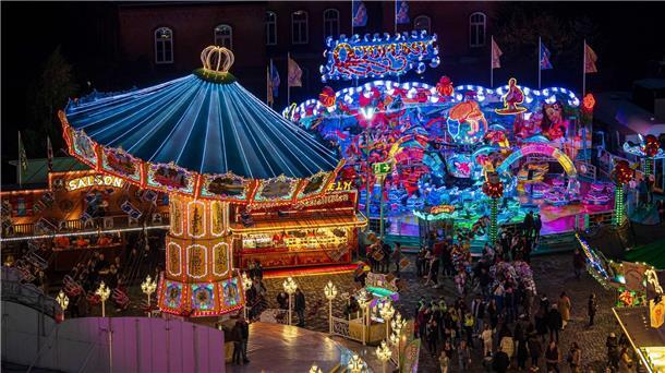 Rund 1,5 Millionen Besucher beim 987. Bremer Freimarkt Die Fahrgeschäfte auf dem Freimarkt leuchten mit bunten Lichtern und Reklameschriftzügen.