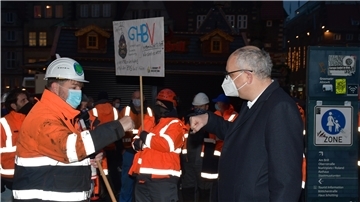 Die Faust zur Begrüßung in Corona-Zeiten: Regierungschef Andreas Bovenschulte (rechts) und GHB-Gesamtbetriebsratsvorsitzender Mirko Basa (links) bei der Kundgebung auf dem Bremer Marktplatz. Bovenschulte sagte den Hafenarbeitern die Unterstützung des Senats zu.