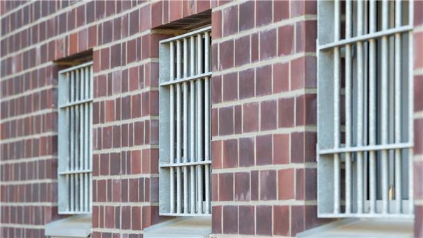 Die Fenster einer Justizvollzugsanstalt sind vergittert.