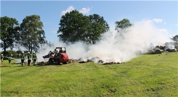 Die Feuerwehr löscht die Heuballen in der Feldmark in Ostereistedt mit Hilfe von Landwirten.