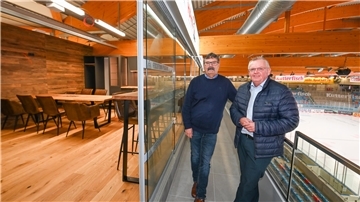 Zwei Personen stehen in einer der neuen Logen in der Eisarena Bremerhaven. Es sind Alfred Prey, General Manager der Fischtown Pinguins, sowie Torsten Neuhoff, Geschäftsführer der Stadthallen-GmbH.
