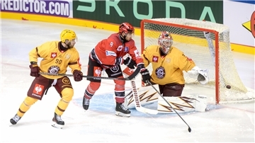 Ein Eishockey-Spieler fährt vor dem Tor des Gegners und versucht den Puck ins Tor zu bekommen. 