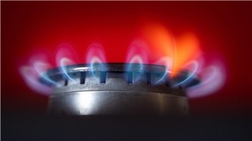 Die Flamme eines Gasherdes brennt in einer Küche.
