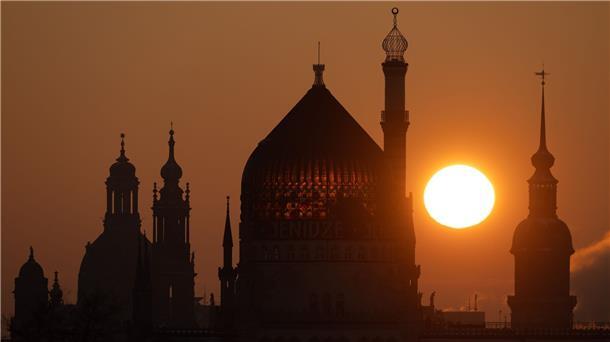Die Frauenkirche, die Katholische Hofkirche, das ehemalige Fabrikgebäude der Zigarettenfabrik Yenidze und der Schlossturm zeichnen sich bei Sonnenaufgang als Silhouette ab.