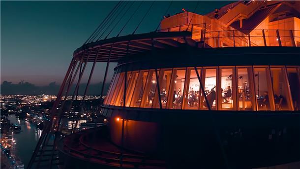 Die ganze Magie Bremerhavens: Das Atlantic Sail City Hotel, von Drohnen umkreist, wurde in der Abenddämmerung aufregend illuminiert. Oben steht DJ Cas Paris, unten in de Captain’s Lounge spielt das Orchester.