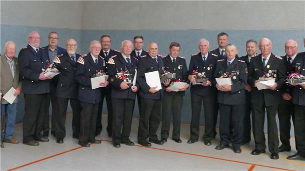 Die Geehrten vom Stadtfeuerwehrtag 2022 in Elmlohe (vorne), dahinter v.l. Bürgermeister Thorsten Krüger, Stadtbrandmeister Friedrich Meyerherm, Brandschutzabschnittsleiter Michael Rins, Kreisbrandmeister Kai Palait und stv. Stadtbrandmeister Michael Fulle. 