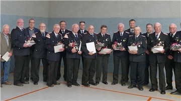 Die Geehrten vom Stadtfeuerwehrtag 2022 in Elmlohe (vorne), dahinter v.l. Bürgermeister Thorsten Krüger, Stadtbrandmeister Friedrich Meyerherm, Brandschutzabschnittsleiter Michael Rins, Kreisbrandmeister Kai Palait und stv. Stadtbrandmeister Michael Fulle. 