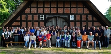 Eine große Gruppe Menschen vor einem Fachwerkhaus