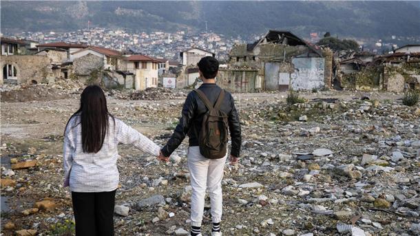 Die Geschwister Arzu (l) und Mehmet stehen in den Trümmern der Altstadt von Antakya. Beide waren bei dem Beben vor einem Jahr verschüttet worden.
