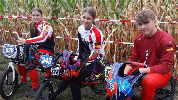 Drei Jugendliche sitzen auf BMX-Rädern