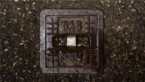Die gusseiserne Straßenkappe einer Gasleitung.