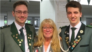 Zwei Männer und eine Frau stehen nebeneinander und gucken in die Kamera.