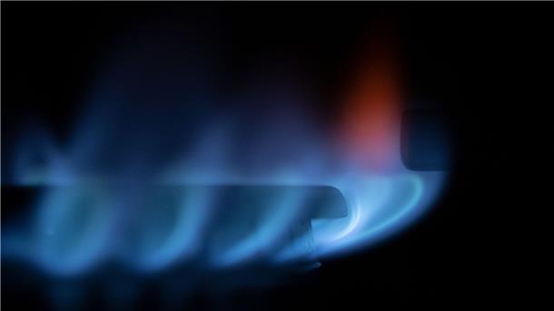 Eine Gasflamme brennt auf einem Küchenherd in einer Wohnung. 