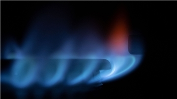Eine Gasflamme brennt auf einem Küchenherd in einer Wohnung. 