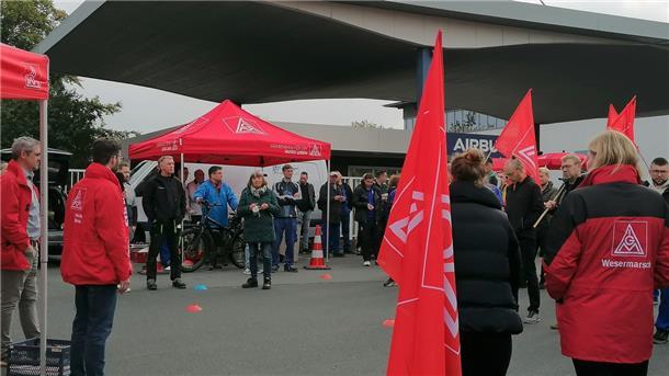Eine Menge von Menschen steht vor dem Airbus Werktor in Nordenham.