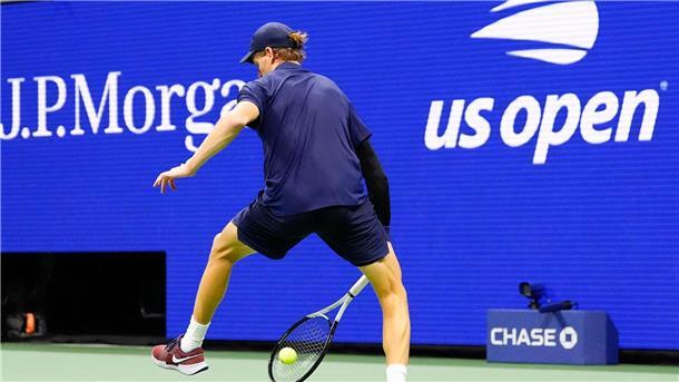 Die italienische Tennisprofi Jannik Sinner wehrt einen Schlag des Kanadiers Auger-Aliassime zwischen seinen Beinen ab.