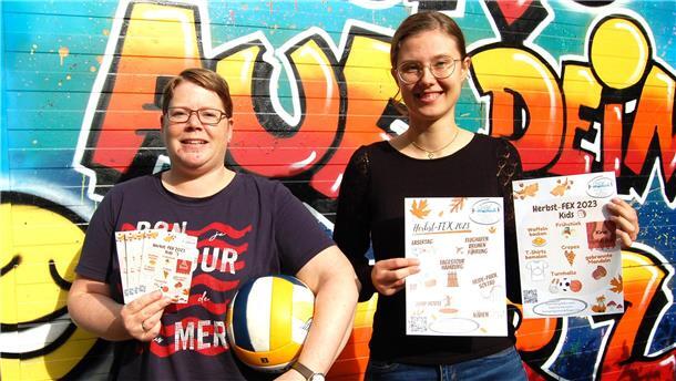  Jugendpflegerin Frauke Evers und FSJ-lerin Lena Böcker halten Flyer für das Herbstferienprogramm der Jugendpflege Hagen in Händen