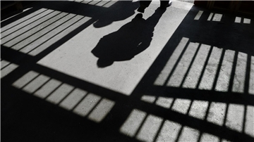 Mann und Gefängnisgitter werfen Schatten