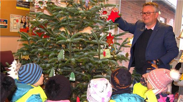 Kinder schmücken einen Weihnachtsbaum.