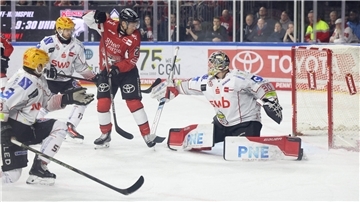 Ein Kölner Eishockeyspieler fälscht eine Scheibe vor dem Bremerhavener Tor ab.