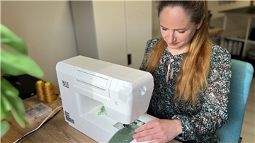 Eine Frau sitzt an einer Nähmaschine