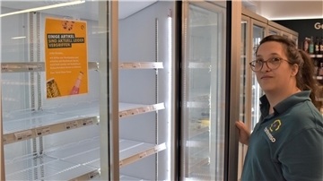 Eine Frau vor einem leeren Kühlschrank