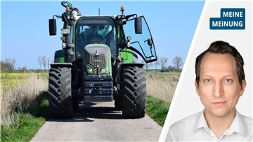 In der linken Hälfte des Bildes ist ein Traktor zu sehen. In der rechten Hälfte ist der Kopf eines Mannes im weißen Hemd zu sehen. 
