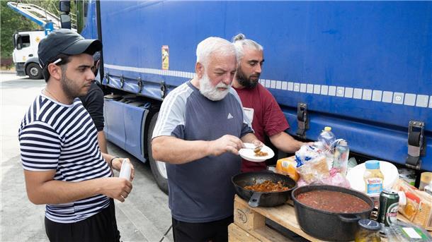 Die Lastwagenfahrer an der südhessischen Autobahnraststätte haben eine Palette  zu einem provisorischen Tisch für ihr Abendbrot umfunktioniert.
