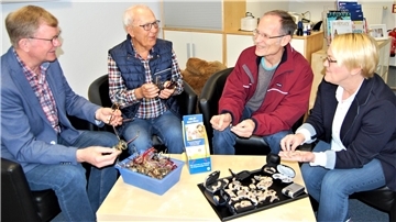 Die Lionsmitglieder Hans-Friedrich Monsees, Peter Heß und Dr. Thomas Dorsch (von links) sichten mit Hörakustikmeisterin Stephanie Reemts die gesammelten Hörgeräte und Altbrillen. Für Menschen in armen Ländern können diese von großem Nutzen sein.