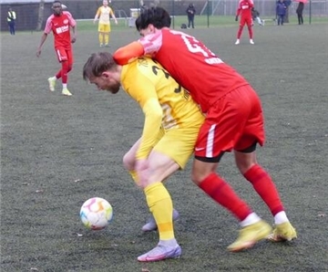 Surheides Marius Bruns im gelben Trikot im Zweikampf mit Dilges Bayrak.