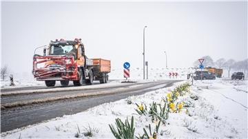 Ein Streufahrzeug fährt über eine Straße.