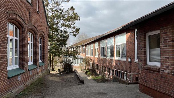 Die Midlumer Grundschule besteht schon jetzt aus mehreren Gebäudeteilen. Ab Frühjahr 2025 soll der jüngste Komplex (rechts) um ein weiteres Gebäude für die Mensa ergänzt werden.