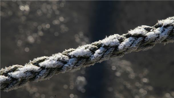 Die Mischung machts: Wasser, Schnee und Frost sorgen für zauberhafte Muster auf rauem Tauwerk im Hafen.
