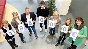 Mitarbeiter der Volksbank im Elbe-Weser-Dreieck halten Schilder in Händen, die zusammen die Spendensumme ergeben: 188.000 Euro