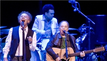 Die Musiker Art Garfunkel (l) und Paul Simon singen bei einem Konzert. Die Dokumentation „Simon & Garfunkel: Traumwandler des Pop" ist am Freitag auf Arte zu sehen.