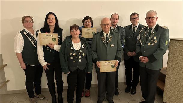 Vier Frauen und vier Männer zum Teil mit einer Urkunde in der Hand.