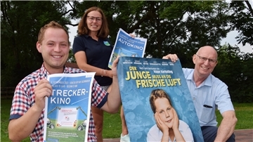 Die Organisatoren der Kinoveranstaltungen zeigen Plakate.