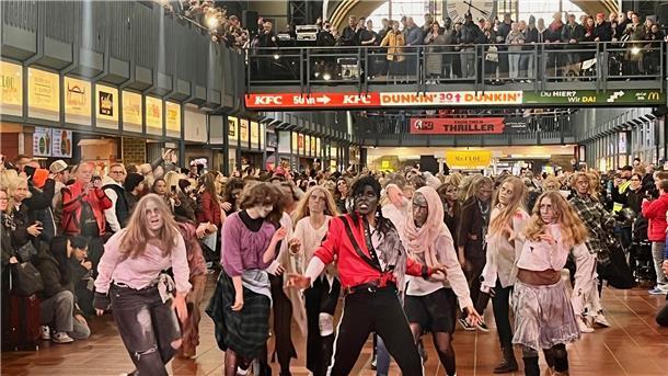 Menschen als Zombies verkleidet tanzen zum Michael-Jackson-Hit "Thriller" im Hamburger Hauptbahnhof.