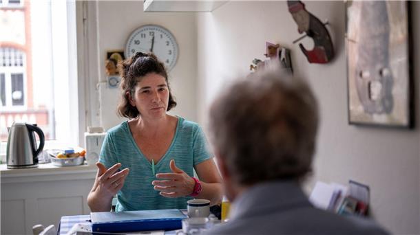 Die Pflegerin Ramona Rössner spricht beim Hausbesuch mit ihrem pflegebedürftigen Patienten Andreas Seltzer.