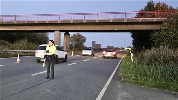 Eine Polizistin steht auf einer Autobahn und regelt den Verkehr.
